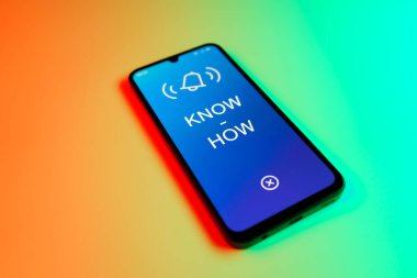 Üniformalı bir arka planda duran cep telefonunun metni ile ilgili bir detay. Bilgi tecrübeyle kazanılır..