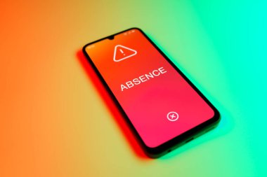 Üniformalı bir arka planda yatan cep telefonunun mesajın eksikliğini gösteren bir detayı. Yokluk, işte bulunmama durumudur..