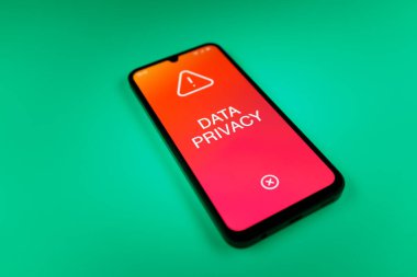 Üniformalı bir arka planda duran cep telefonunun bir ayrıntısı. Mesaj Veri Gizliliği 'ni gösteriyor. Veri Mahremiyeti kişisel ve hassas bilgilerin korunmasıdır.