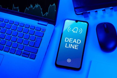 Ofis masası, dizüstü bilgisayarlı ve telefonlu ölü hattı gösteriyor. Bir görevin tamamlanması gereken tarih ölü satırdır.