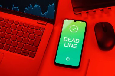 Ofis masası, dizüstü bilgisayarlı ve telefonlu ölü hattı gösteriyor. Bir görevin tamamlanması gereken tarih ölü satırdır.