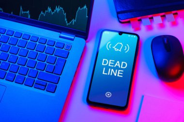 Ofis masası, dizüstü bilgisayarlı ve telefonlu ölü hattı gösteriyor. Bir görevin tamamlanması gereken tarih ölü satırdır.