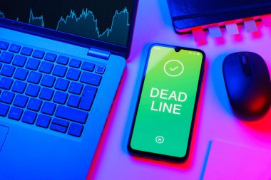 Ofis masası, dizüstü bilgisayarlı ve telefonlu ölü hattı gösteriyor. Bir görevin tamamlanması gereken tarih ölü satırdır.