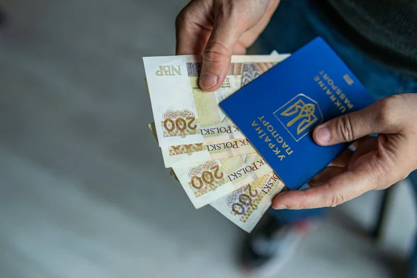 Elinde 800 'den fazla Polonya zloti banknotuyla Ukrayna pasaportu. Göç kavramı, mülteci desteği, sosyal yardım, mali yardım ve sınır ötesi geçiş.