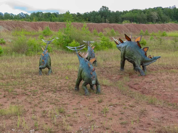 Jura Park Krasiejow. Polonya. 6.09.2025. Sırtlarında çivili kuyrukları ve plakaları olan bir grup Stegosaurus heykeli tarih öncesi tema parkında sergileniyor..
