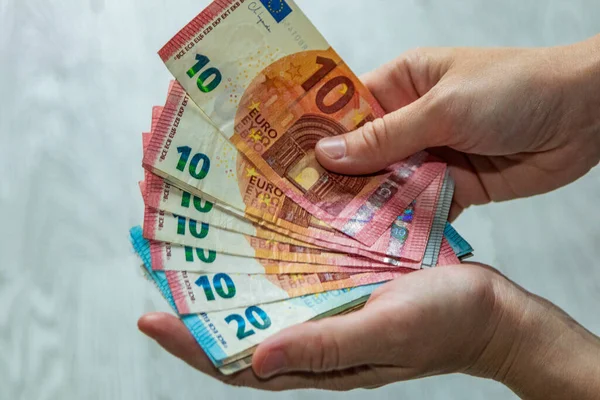 Avro banknotlarının hayranıyla el ele tutuşun. Maaş, tasarruf, bütçe, zenginlik ve finansal planlama kavramı. Farklı değerlerde Avrupa kağıt para birimi.