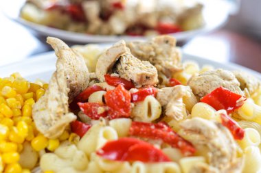 Sıcak makarna tavuk göğsü et ve sebze ahşap masa, yakın çekim üzerinde büyük beyaz plaka ile. Gıda arka plan