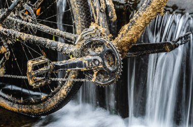 Kirli dağ bisikleti bir dere küçük şelale karşı duruyor. Kirli zinciri sürücü dağ bisikleti yakın çekim. Bir bisiklet kavram Temizleme
