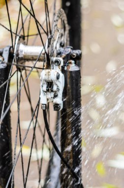 Dağ bisikleti bir su jeti ile yakın çekim yıkama. Ön fren alanı. Beyaz renk ön fren Kaliper
