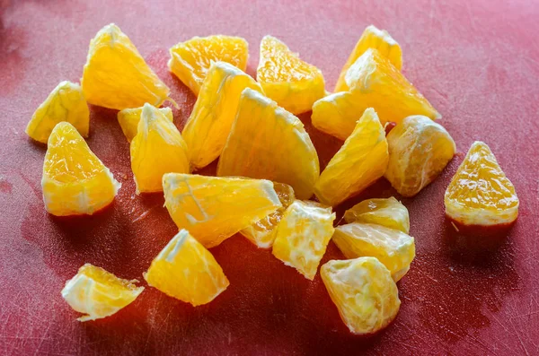 Finthakket Stykker Frisk Appelsin Red Cutting Board - Stock-foto