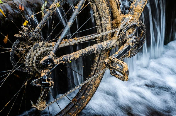 Kirli dağ bisikleti bir dere küçük şelale karşı duruyor. Kirli zinciri sürücü dağ bisikleti yakın çekim. Bir bisiklet kavram Temizleme