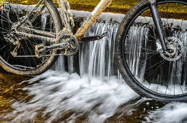 Kirli dağ bisikleti bir dere küçük şelale karşı duruyor. Kirli zinciri sürücü dağ bisikleti yakın çekim. Bir bisiklet kavram Temizleme