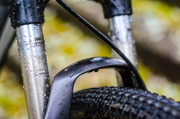 Washing Dirty Mountain Bike Suspension Fork After Riding in Bad Weather. Wet, Dirt and Oil Stains on the Legs of the Mountain Bike Fork