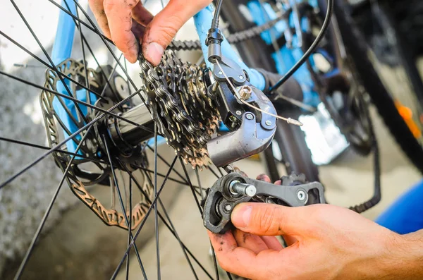 Kırık Bisiklet Arka Vites Deitirici. Eller ayrı ikiye düştü Arka Vites Deitirici parçaları tutmak. Bir arıza tamir etmeye çalıştığını.