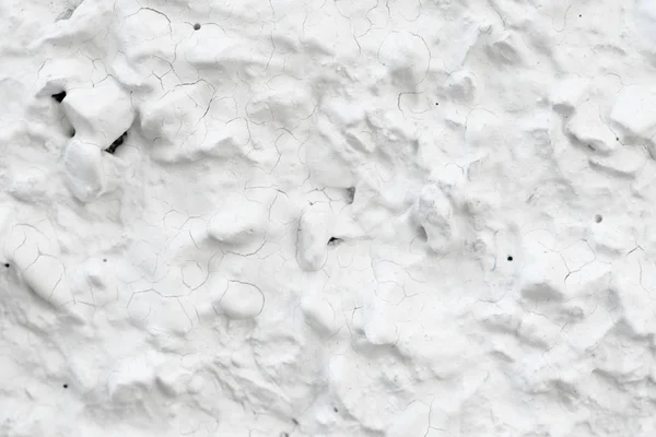 Rough Concrete Wall Decoration, Painted White. White Concrete Wall with Many Protruding Stones.