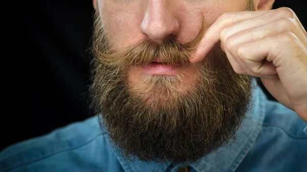 Hombre Barbudo Con Una Camisa Mezclilla Azul Girando Bigote Con —  Fotos de Stock