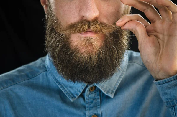 Bebaarde Man Een Blauw Denim Shirt Twirling Zijn Snor Met — Stockfoto