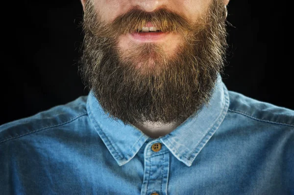 ひげを生やした男は黒い背景に青いデニムのシャツで笑顔の肖像画 流行に敏感な一見 ひげと口ひげのクローズ アップ — ストック写真