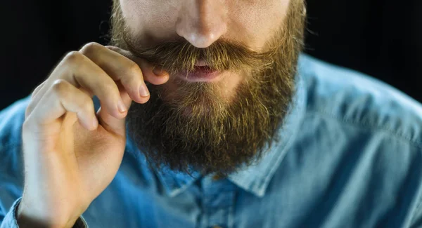 Bärtiger Mann Blauem Jeanshemd Der Seinen Schnurrbart Mit Den Fingern — Stockfoto