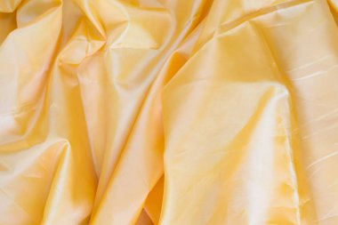 Sarı sentetik astar kumaş kıvrımları ile. Buruşuk sayfa veya elbise arka plan,