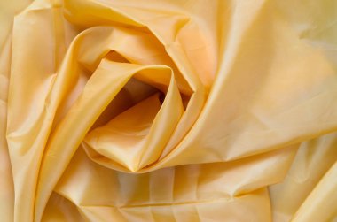 Sarı sentetik astar kumaş kıvrımları ile. Buruşuk sayfa veya elbise arka plan,