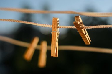 Clothesline bir mavi gökyüzü arka plan üzerinde ahşap clothespins dönüştürün