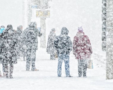 Blizzard bir kentsel ortamda. Kar yağışı otobüs durağı insanlar. Soyut bulanık kış hava arka plan
