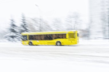 Sarı otobüs ile bir kar fırtınası sırasında grubunu bir yol gidiyor. Arka plan bulanıklık. Kış koşullarında tehlikeli yol kavramı