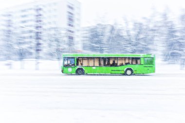 Yeşil şehir otobüs ile bir kar fırtınası sırasında grubunu bir yol gidiyor. Arka plan bulanıklık. Kış koşullarında tehlikeli yol kavramı