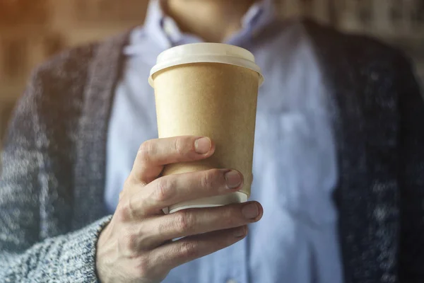 Office worker is holding a cup of coffee. Coffee break Hand Paper cup Cardigan Blue shirt. Coffee Break Concept