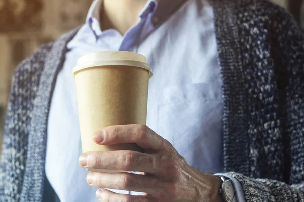 Office worker is holding a cup of coffee. Coffee break Hand Paper cup Cardigan Blue shirt. Coffee Break Concept