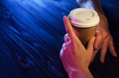 Masadaki sevgi dolu bir çift. Üstten görünüm. Kağıt bardak plastik kap ahşap tablo güzel açık eller