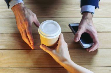 Barista kahve birine sunmaktadır. El kağıt bardak plastik kap ahşap masa Break Blazer. Kahve molası kavramı