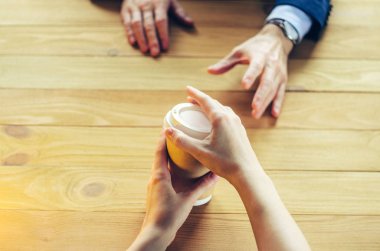 Barista kahve birine sunmaktadır. El kağıt bardak plastik kap ahşap masa Break Blazer. Kahve molası kavramı