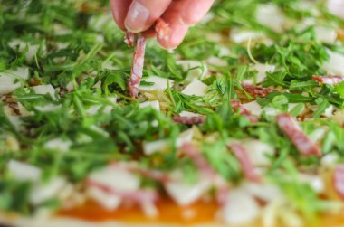 Pizza yapma işlemi. Mantar, ruccola, domates, mozzarella peyniri, sarmısak ve sos İtalyan biberli pizza. Chef malzemeler pizza için ekler.