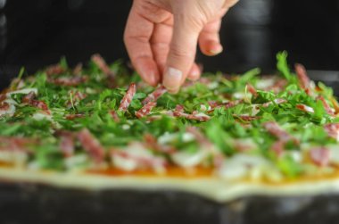 Pizza yapma işlemi. Mantar, ruccola, domates, mozzarella peyniri, sarmısak ve sos İtalyan biberli pizza. Chef malzemeler pizza için ekler.