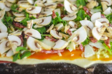 Pizza yapma işlemi. İtalyan biberli pizza mantar, ruccola, domates, mozzarella peyniri, sarmısak ve sos ile