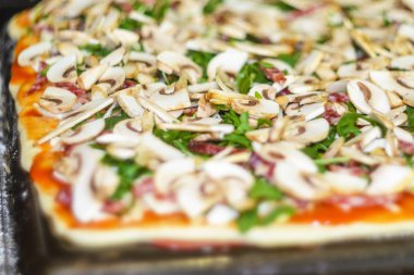 Pizza yapma işlemi. İtalyan biberli pizza mantar, ruccola, domates, mozzarella peyniri, sarmısak ve sos ile