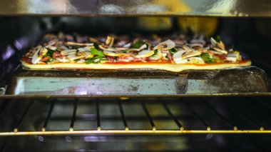 Pizza yapma işlemi. Mantar, ruccola, domates, mozzarella peyniri, sarmısak ve sos İtalyan biberli pizza. Biberli pizza fırın