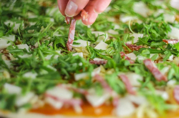 Pizza yapma işlemi. Mantar, ruccola, domates, mozzarella peyniri, sarmısak ve sos İtalyan biberli pizza. Chef malzemeler pizza için ekler.