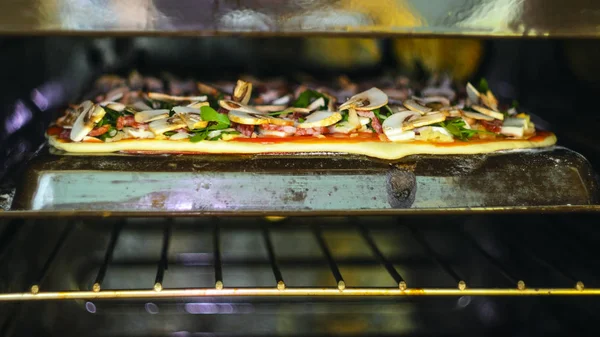 ピザを作るプロセス イタリア ピーマン マッシュルーム ルッコラ トマト モッツァレラチーズ ニンニクとソースのピッツァオーブンでペパロニピザ — ストック写真