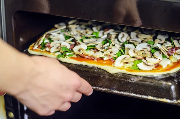 Pizza yapma işlemi. Mantar, ruccola, domates, mozzarella peyniri, sarmısak ve sos İtalyan biberli pizza. Şef biberli pizza fırından çeker. Taze pişmiş biberli Pizza