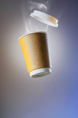 Kağıt bardak sıcak bir kahve üzerinden buharlaşma ile levitating. Sıcak bir içecek Buhar kulüpler. Kağıt bardak düzeni reklam için. Kağıt bardak kahve plastik bir kap ile havada havalanır