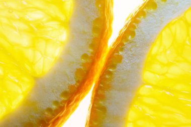 Beyaz zemin üzerine portakal dilimleri. Parlıyor. Makro görüntü arka planı için olgunlaşmış Orange.