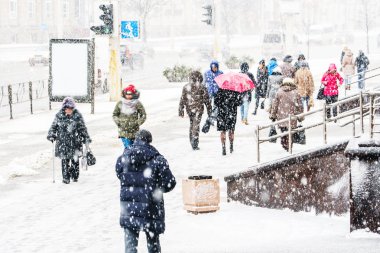 Blizzard bir kentsel ortamda. Kırmızı şemsiye insanlar kar yağışı acele bir kalabalık içinde olan bir kadın silueti. Soyut bulanık kış hava arka plan.