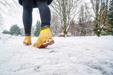 Kış yürüyüş sarı deri çizmeli. Arkadan görünüm buzlu karlı kaldırım yürüyen bir adam ayakları üzerinde. Kışın buzlu yolda Ayakkabı çifti. Boş boş kış hava arka plan