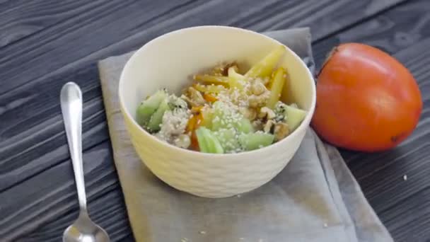 Healthy Food Oatmeal Persimmon Kiwi Walnuts Sesame Seeds Deep Bowl — Stock Video