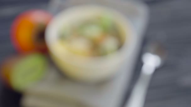 健康食品 深いボウルビューで柿 キウイ クルミ ゴマとオートミール — ストック動画