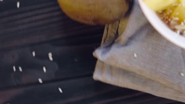 Une nourriture saine. Farine d'avoine au kaki, kiwi, noix et graines de sésame dans un bol profond vue du dessus 