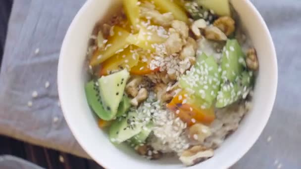 Healthy Food Oatmeal Persimmon Kiwi Walnuts Sesame Seeds Deep Bowl — Stock Video